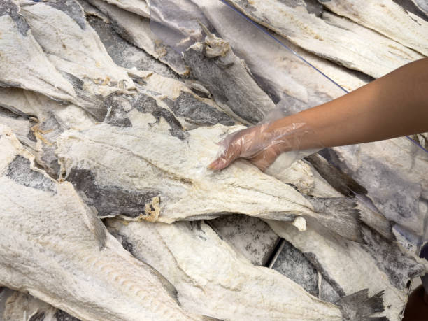 Female hand selecting cod on the shelf